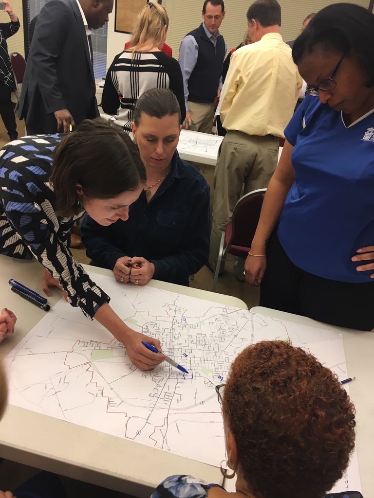 Planning Meeting - Groups of people gathered around maps of Brenham