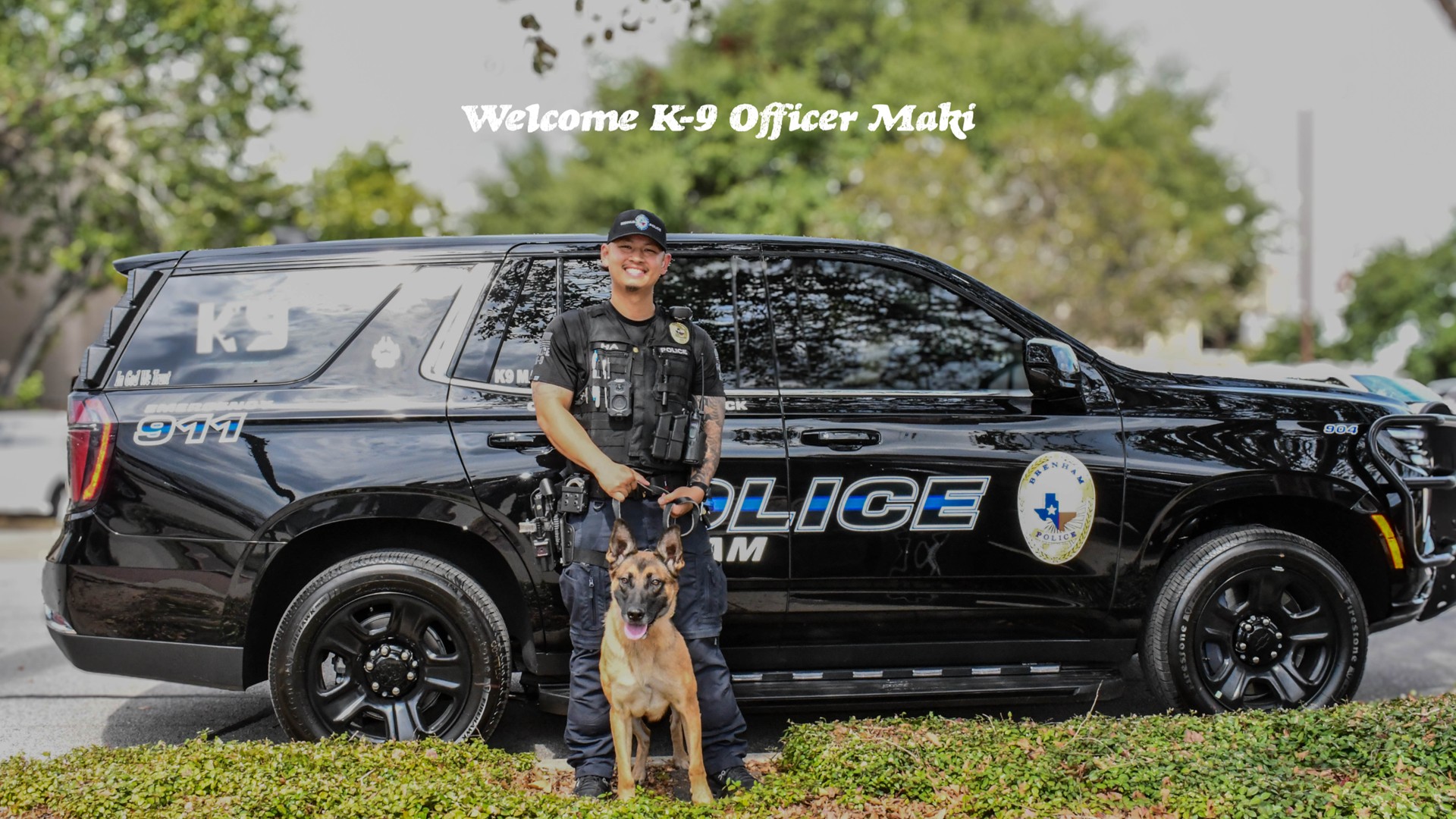 K9 officer Maki and officer Jimmy Ha pose in front of a police patrol vehicle