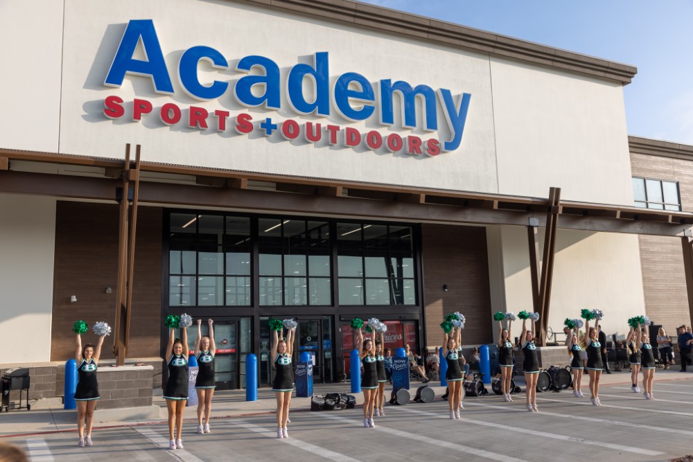 Academy Sports + Outdoors store front with Brenham high school cheerleaders
