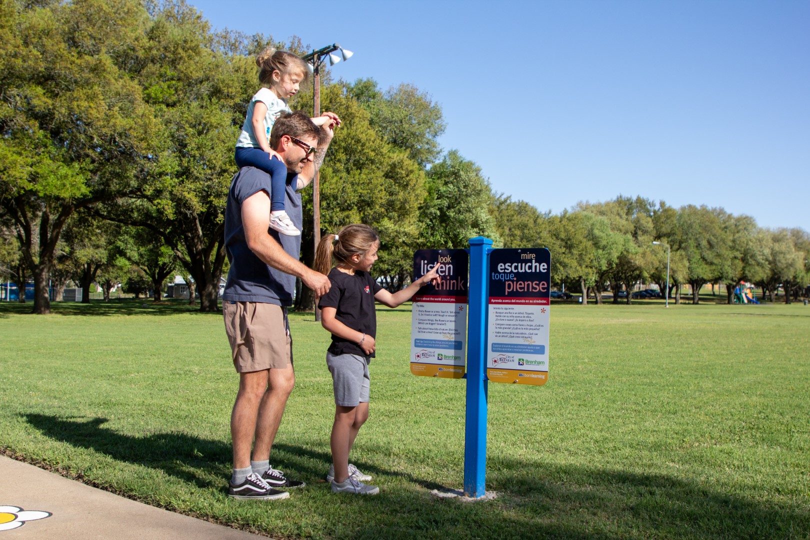 family looking at born learning sign in Jackson Street Park