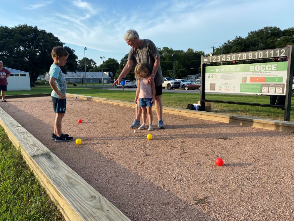 kids learning how to play bocce at Jackson Street Park with family